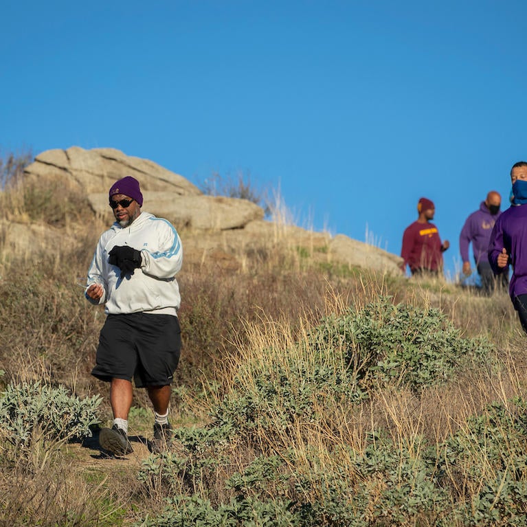 Barbershop Walk participants head down a hill, led by Bert Wright. (UCR/Stan Lim)