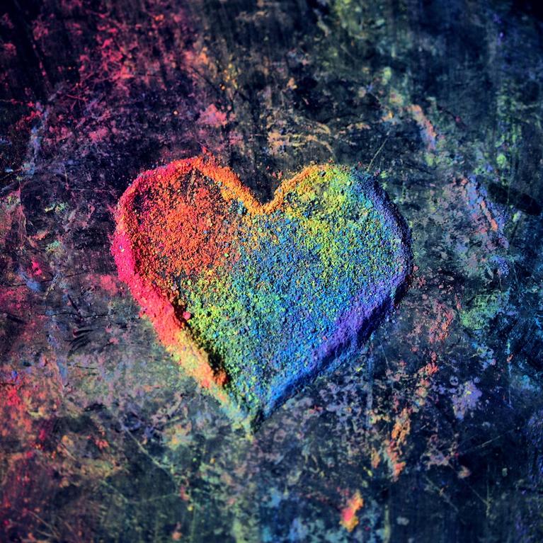 An LGBT-themed heart made of rainbow chalk dust