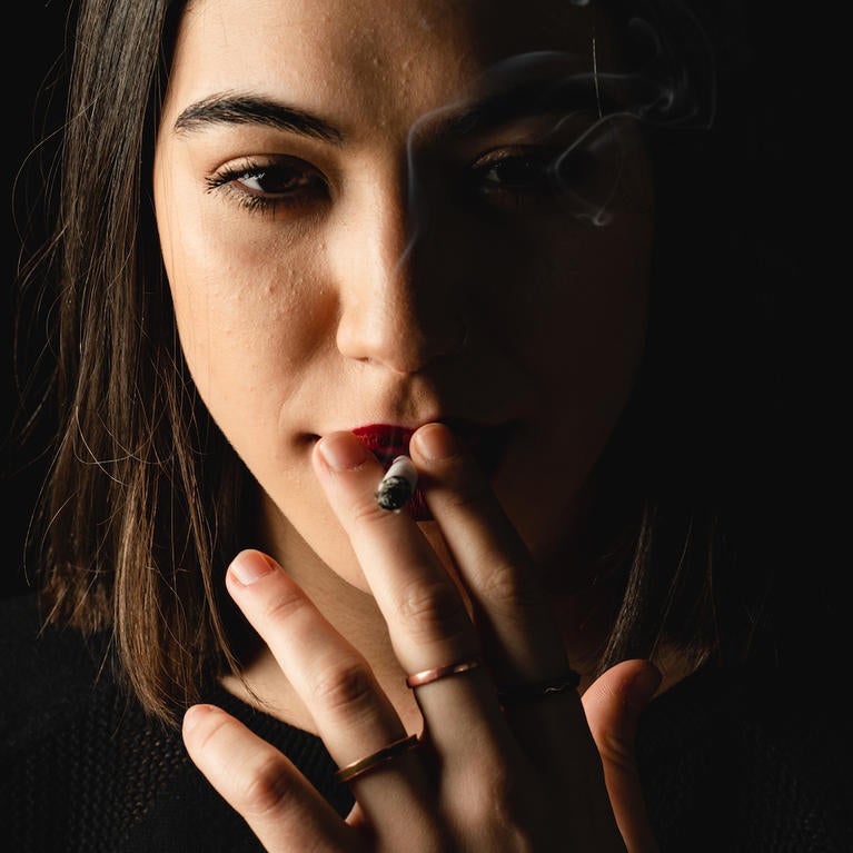 A young woman smokes a cigarette