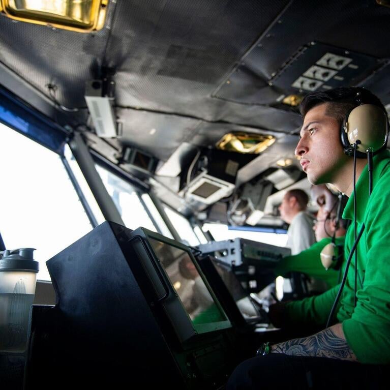 Military at ship control panels