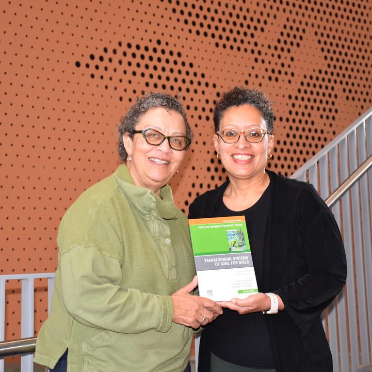 Michelle Porche and Lisa Fortuna hold a book