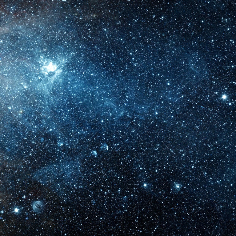 An image of space filled with stars, galaxies, and a nebula.