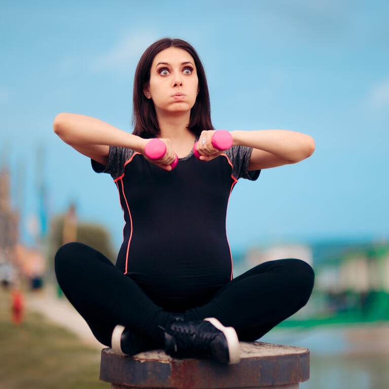 Pregnant woman holding weights