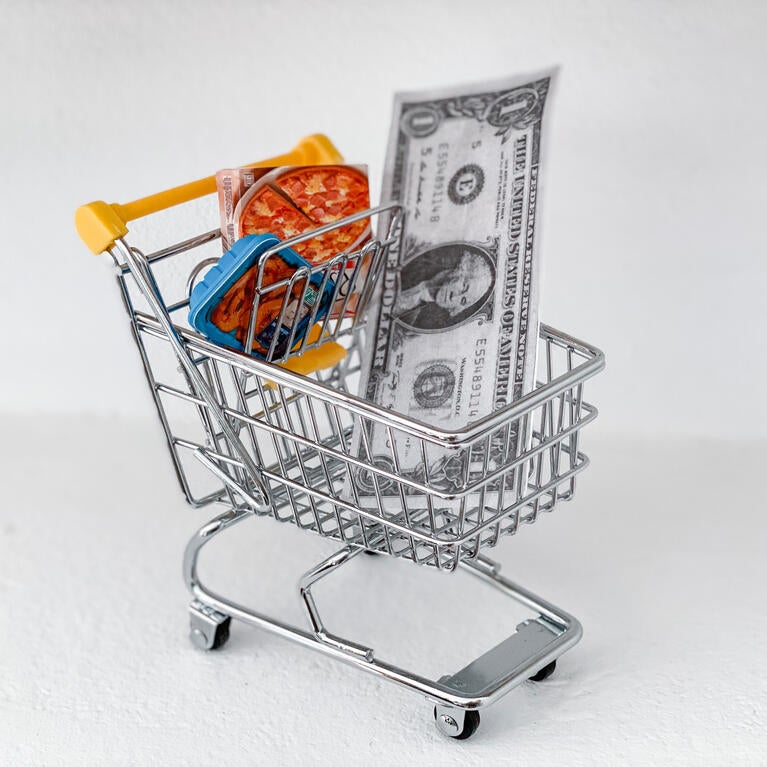 Shopping cart with a dollar and frozen pizza