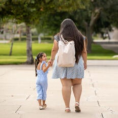 Mother and daughter walking and holding hands.