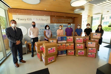Representatives of the UCR School of Medicine receive boxes of surgical masks from the Chinese Americans Donation Center