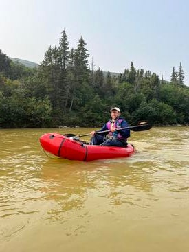 Scientist in a raft on rusty Alaskan waters
