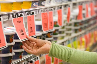 Market customer checking food price tag