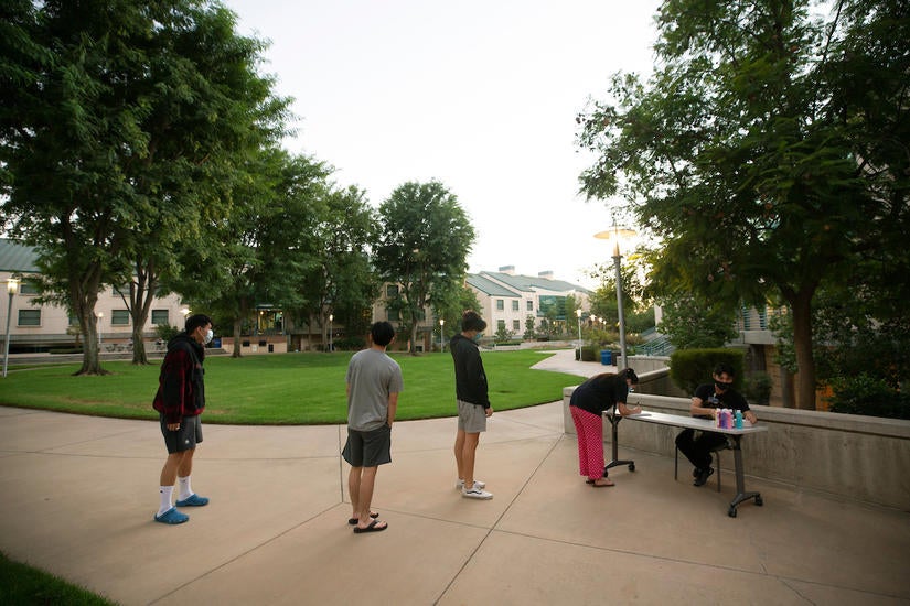 Students lined up to pick up paint night supplies with their RA Thomas Valenzuela. (UCR/Stan Lim)