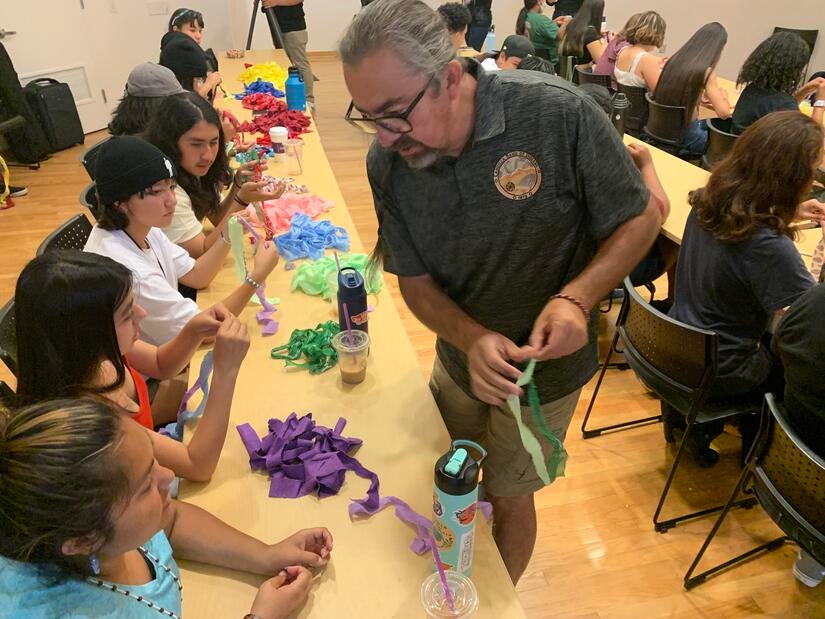 Gathering of the Tribes participants making traditional rope, known as cordage, with the help of artist and professor of ethnic studies, Gerald L. Clarke, Jr. The workshop, titled, "Art is Medicine," was held on Thursday, June 23, 2022 at UC Riverside. (UCR/Sandra Baltazar Martínez)