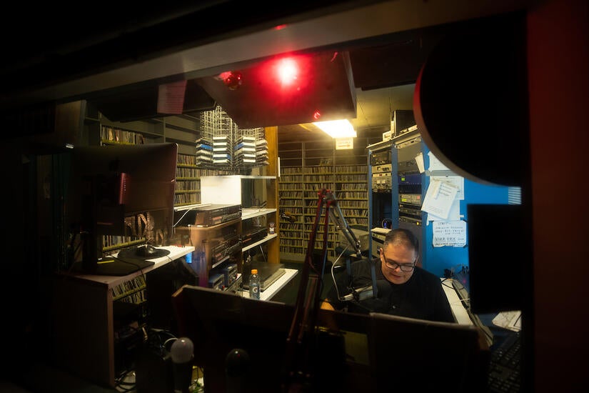 Richard T. Rodríguez, professor of English and media and cultural studies, is also a DJ on KUCR. He appears every Thursday night as "Dr. Ricky on the Radio." On Thursday, September 1, 2022, he prepared to go on the air.  (UCR/Stan Lim)