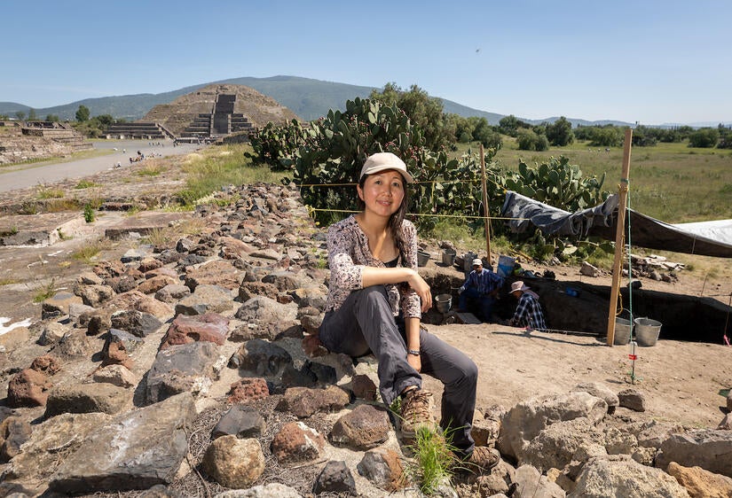 Nawa Sugiyama, assistant professor of anthropology, sits near an excavation pit in Totihuacán, Mexico in August 2023. The Pyramid of the Moon is in the background.(UCR/Stan Lim)