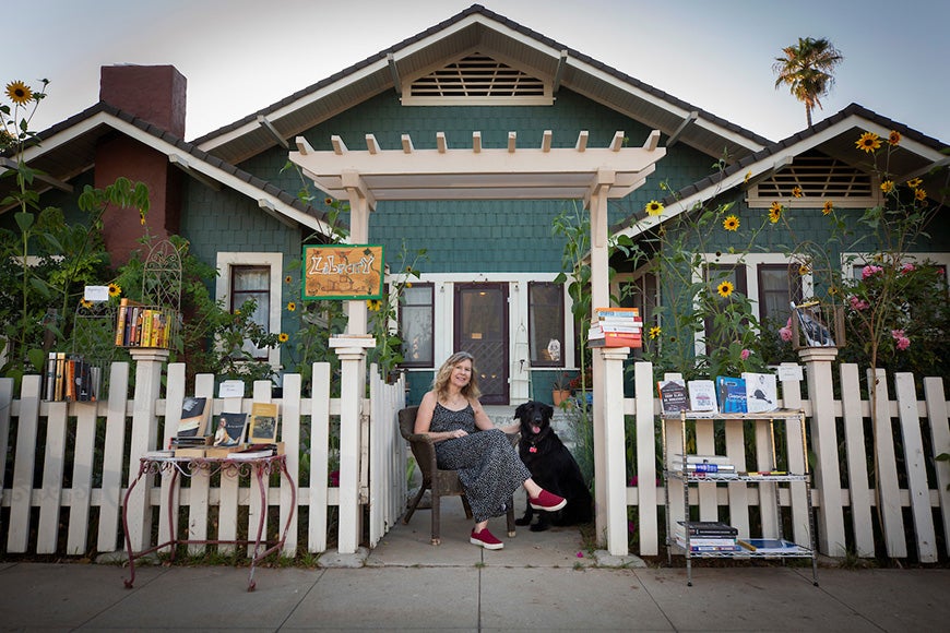 Fence Library 3 Susan Straight sitting outside home with dog, Angel.