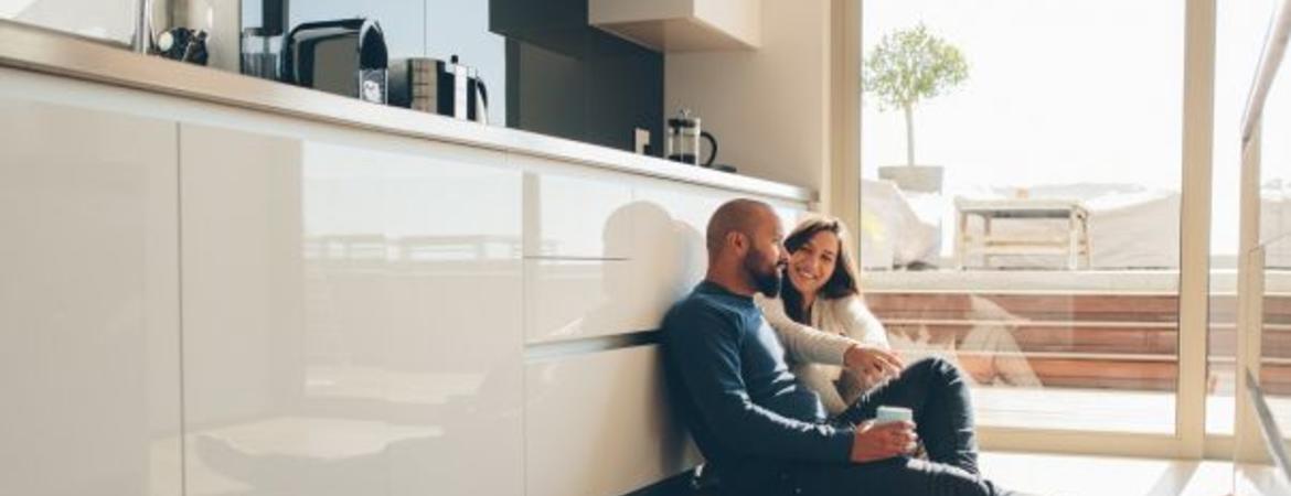 couple sitting on floor of kitchen