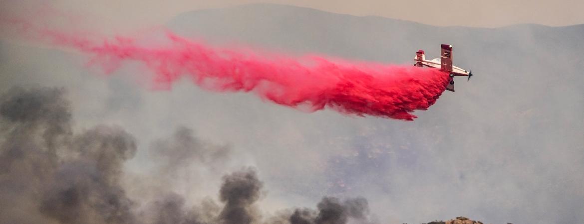 A plane drops pink fire retardant on a wildfire in Utah