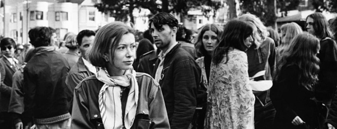 Writer Joan Didion walks among hippies during a gathering in Golden Gate Park, San Francisco