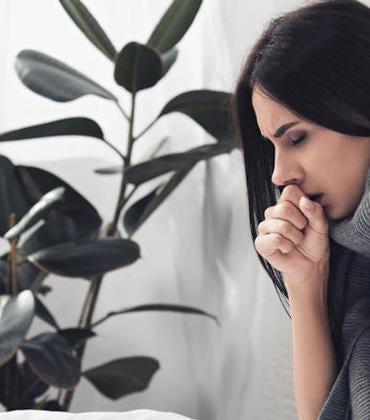 woman coughing with respiratory issues