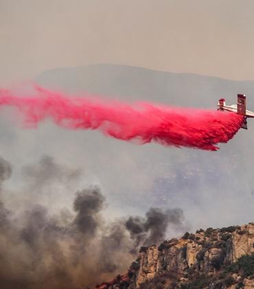 A plane drops pink fire retardant on a wildfire in Utah