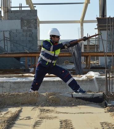 A construction worker bends rebar