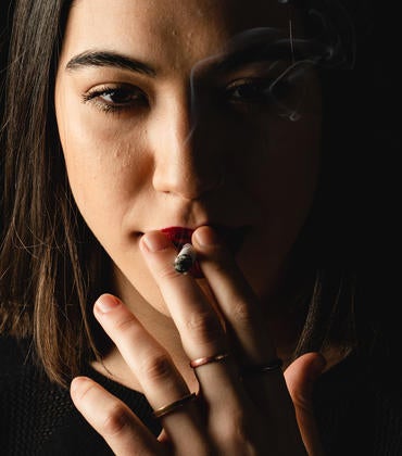 A young woman smokes a cigarette