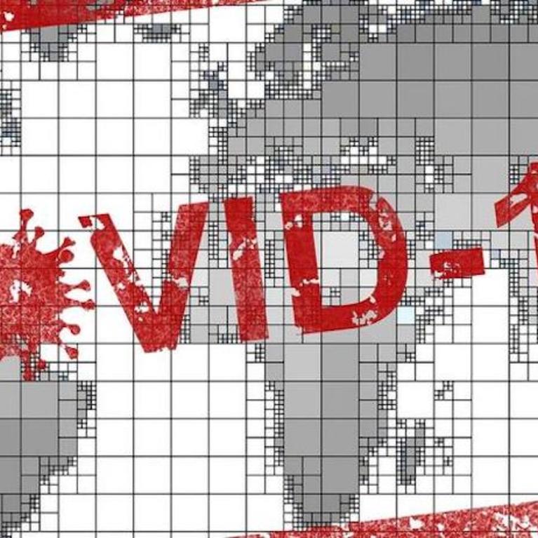 A global map with the word "COVID-19" written across it
