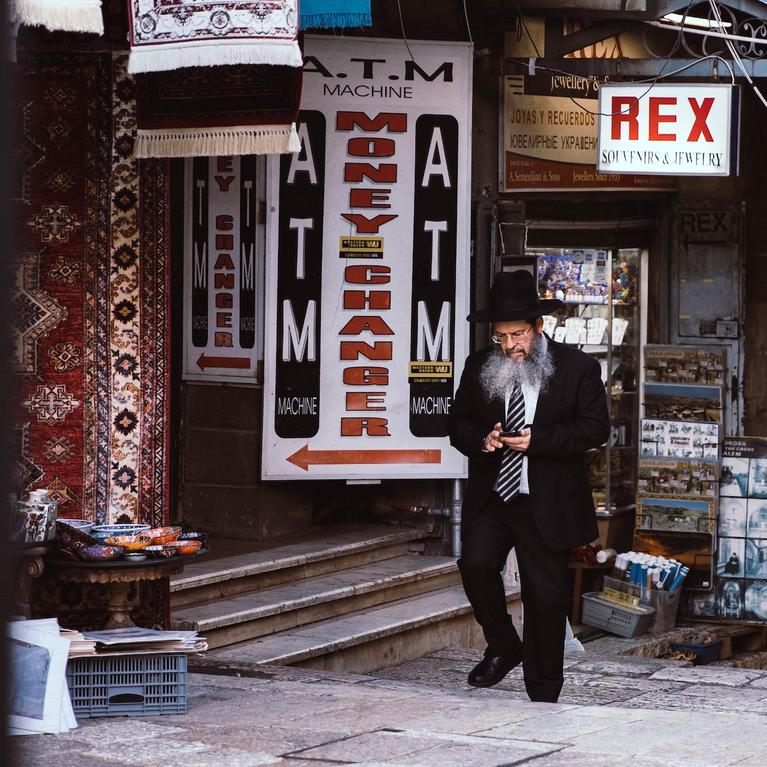 A Jewish man walks through a market place. 