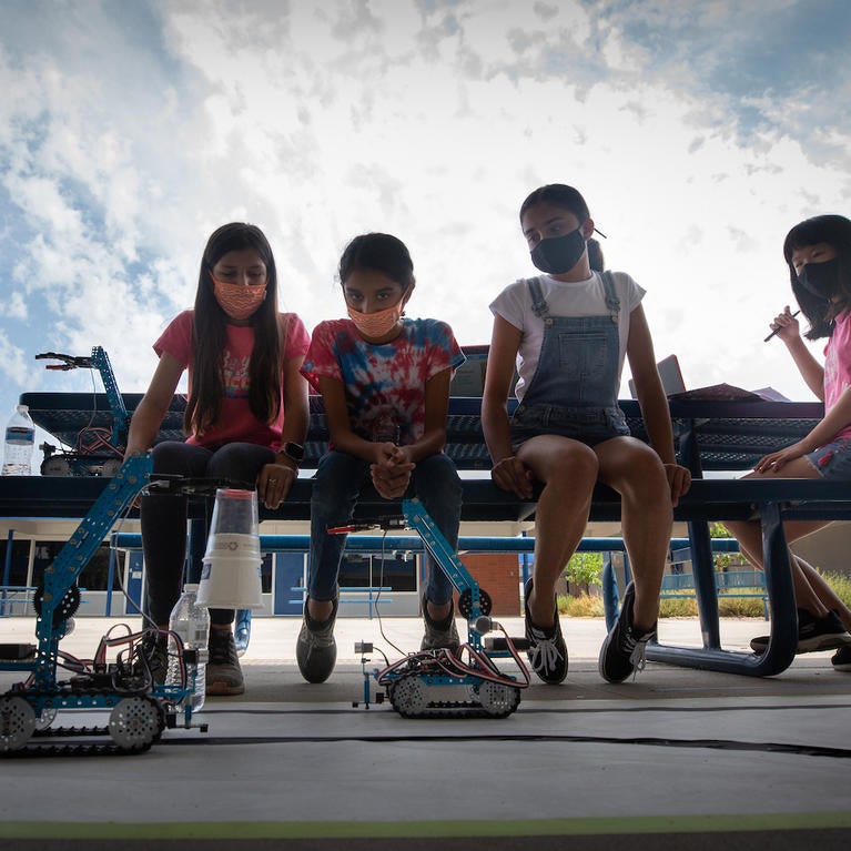 Middle school girls watch a robot they made at a UC Riverside summer robotics camp