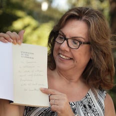 Roseanne Carmen Rosenthal points at the autographed text written by Robert Rosenthal, UCR distinguished professor of psychology, one of the world’s most influential psychologists. (UCR/Stan Lim)