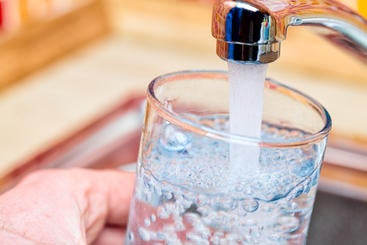 Tap water A picture of someone filling a glass with tap water