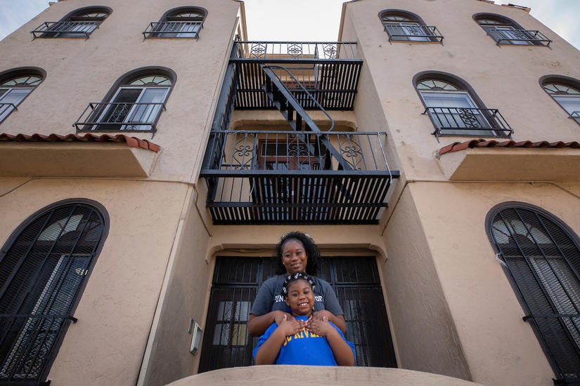 Deidre Reyes, 46, with her daughter Kaylynn Coleman, 7, outside the apartment complex Reyes grew up in Los Angeles on March 24, 2021. (UCR/Stan Lim)